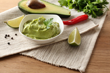 Fresh guacamole in bowl on table