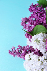 Beautiful bouquet of lilac flowers on color wooden background