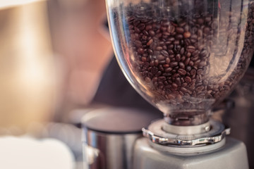 Coffee grinder and Barista prepares espresso in coffee shop - obrazy, fototapety, plakaty