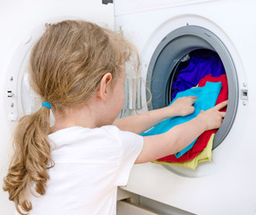Little girl doing laundry. Housework concept.