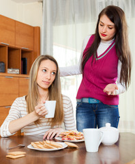 women having quarrel over tea table