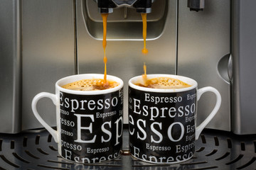 Two espresso cups filled by an automatic espresso machine