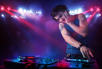 Plakat Teenager dj mixing records in front of a crowd on stage