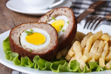 by scotch egg and fried potatoes close-up