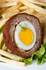 by scotch egg with french fries macro. Vertical