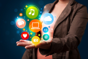 Young woman presenting colorful technology icons and symbols