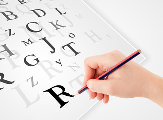 Hand writing various letters on white plain paper