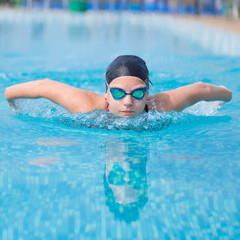 Fototapeta na wymiar Young girl swimming butterfly stroke style