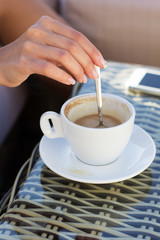 Young woman drinking coffee in a cafe outdoors