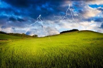Fototapeta na wymiar Thunderstorm with lightning in green meadow