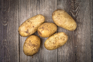 Potatoes on wooden background. Top view.