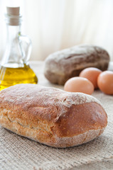 Homemade bread ciabatta on the table. Olive oil, eggs and flour
