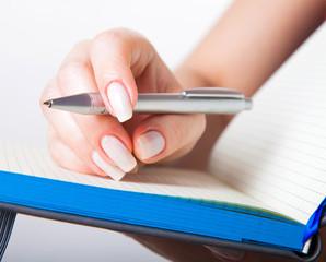 female hand with pen and notebook
