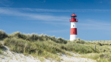 Red - white lightouse on wide dune on amazing German island Sylt. Horizontal. - obrazy, fototapety, plakaty