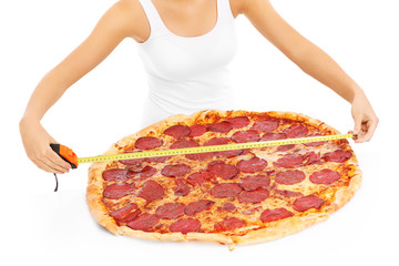 Woman measuring huge pizza