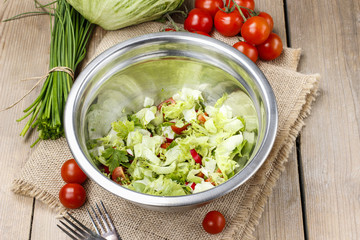 Bowl of fresh salad on wooden table