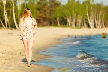 Fototapeta premium Summer vacation. Girl walking alone on the beach.