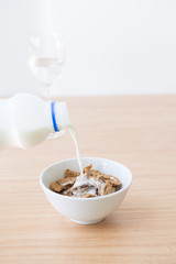 adding milk to cornflake