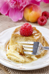 Creme caramel and beautiful pink peonies in the background