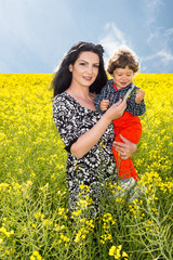 Naklejka na ściany i meble Mother and son in rapeseed field