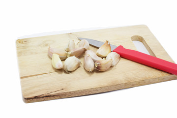 Chopping the garlic with knife on white