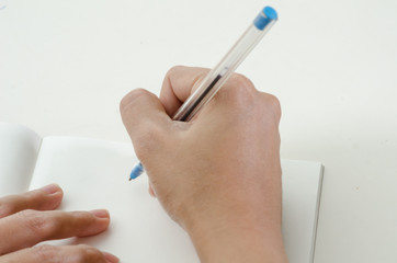 Close-up of a woman drawing into her diary