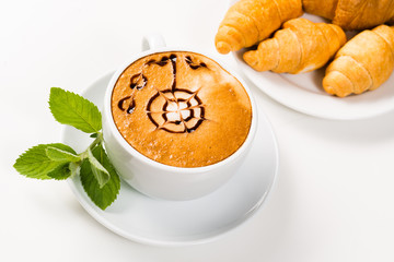 large cup of coffee and croissants on a plate
