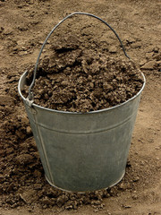 bucket full of soil on dirt background