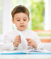 Little boy is reading a book