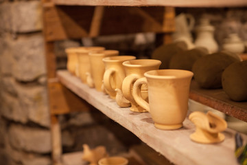 Pottery dishes on shelves in pottery workshop, editorial photo