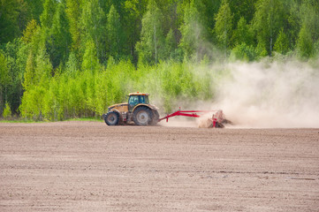 Rural landscape with the tractor cultivating the land.