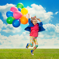 Little girl with balloons jumping on the field