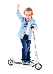 Cheerful boy with raised hand on scooter white background