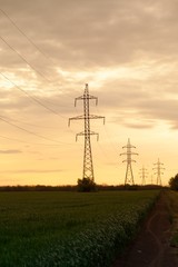 Silhouette of electricity pylons at sunset