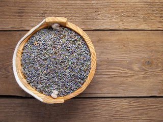 Dried lavender in bucket on wooden background