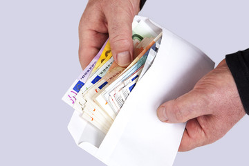 Hand holding envelope with paper money