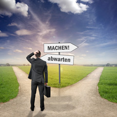 Mann steht an zwei Wegen 