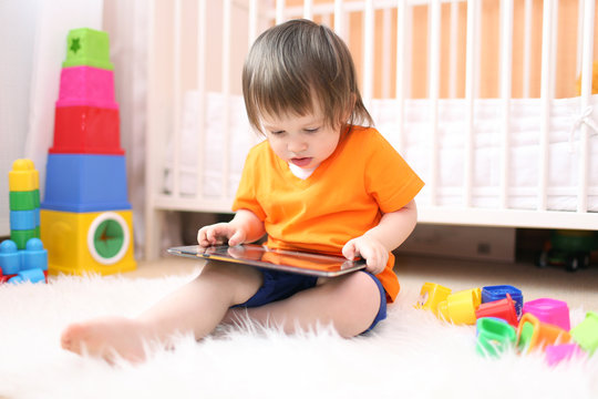 little boy with tablet computer at home
