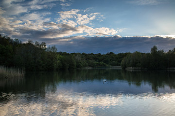 Summer vibrant sunset reflected in calm lake waters