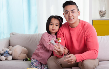 Asian siblings with puppets