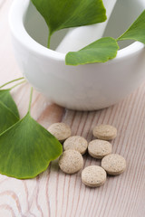 Ginkgo biloba leaves in mortar and pills