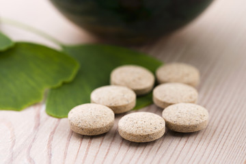 Ginkgo biloba leaves in mortar and pills