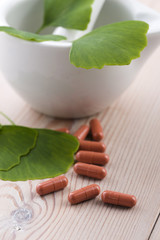Ginkgo biloba leaves in mortar and pills