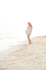 Fototapeta na wymiar Young woman walking on beach in the evening