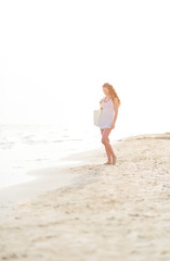Fototapeta premium Young woman walking on beach in the evening