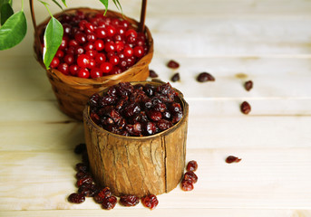 Fresh and dry cranberry in baskets on wooden table