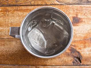 Stainless steel tumbler with ice.