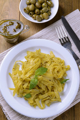 Delicious pasta with pesto on plate on table close-up