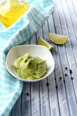 Fresh guacamole in bowl on wooden table