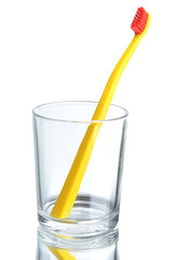 Toothbrush in glass on light grey background